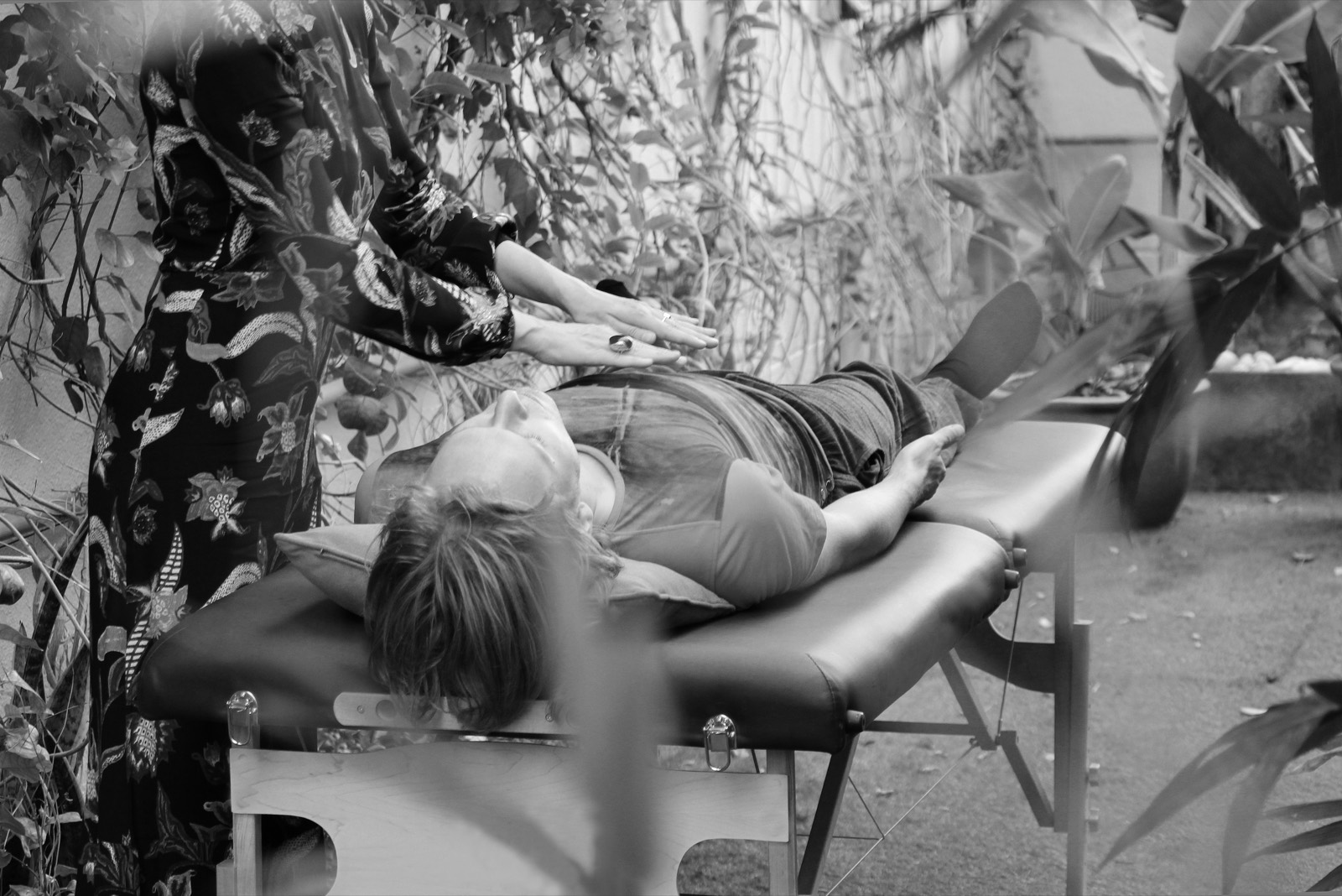 Outdoor Pranic Healing session in a garden, hands held above the client